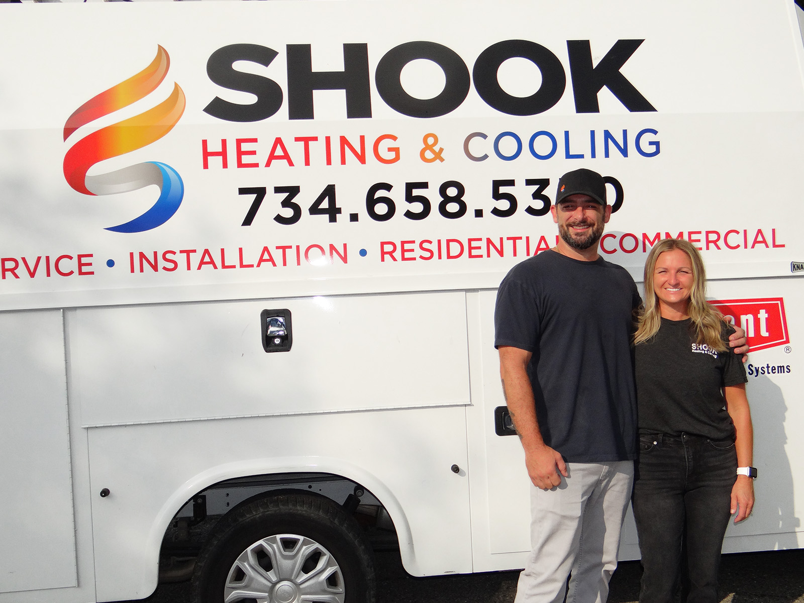 Larry Shook founder of Shook Heating and Cooling with his wife Kara in front of their company service vehicle